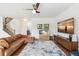 Open living room featuring hardwood floors, large-screen TV, and staircase leading to the second floor at 24356 E Powers Ave, Aurora, CO 80016