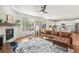 Spacious living room with a brick fireplace, ceiling fan, and a seamless transition to the modern kitchen at 24356 E Powers Ave, Aurora, CO 80016