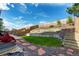 Backyard featuring retaining wall, grass lawn, and stone pavers, offering a serene outdoor space at 5972 S Zante Way, Aurora, CO 80015