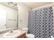 Well-lit bathroom with a functional vanity, toilet, and shower featuring a stylish black-and-white curtain at 5972 S Zante Way, Aurora, CO 80015