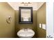 Charming powder room with a modern pedestal sink, mirror, and stylish fixtures at 5972 S Zante Way, Aurora, CO 80015