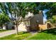 Side view of a beige two-story home with a two car garage, grass, and blue skies at 5972 S Zante Way, Aurora, CO 80015