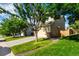 Side view of a beige two-story home with a two car garage, grass, and blue skies at 5972 S Zante Way, Aurora, CO 80015