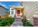 Charming front porch with a red door, lush greenery, and a cozy seating area at 5972 S Zante Way, Aurora, CO 80015