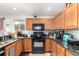 Modern kitchen with granite countertops, black appliances, and bright natural lighting at 5972 S Zante Way, Aurora, CO 80015