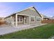 Back exterior view of a house with a covered porch and grassy lawn at 10049 Isle St, Parker, CO 80134