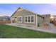 Rear exterior of home featuring an olive green exterior, back patio and green lawn at 10049 Isle St, Parker, CO 80134
