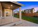 View of a back porch with wooden floor, a green grass lawn, and fenced in yard at 10049 Isle St, Parker, CO 80134