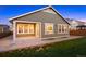 Exterior view of home with covered back porch, hardscaped patio and lawn at 10049 Isle St, Parker, CO 80134