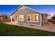 Inviting covered porch, stone patio, and lush green lawn enhance the home's outdoor living space at 10049 Isle St, Parker, CO 80134