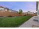 Backyard with grass, mulch beds, and wood privacy fence, plus concrete walkway at 10049 Isle St, Parker, CO 80134