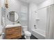 Stylish bathroom features geometric wallpaper, wood vanity, and shower with a tub at 10049 Isle St, Parker, CO 80134