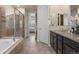 Bathroom with a large soaking tub, walk-in shower, double vanity, and tile floors at 10049 Isle St, Parker, CO 80134