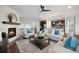 Comfortable living room open to kitchen with a fireplace, ceiling fan, and hardwood floors at 10049 Isle St, Parker, CO 80134