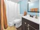 Fresh bathroom featuring blue walls, new vanity, toilet and a shower with white curtain at 10781 Moore St, Westminster, CO 80021