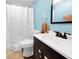 Modern bathroom featuring bright blue walls, vanity, toilet, and shower with white curtain at 10781 Moore St, Westminster, CO 80021