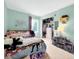 Serene bedroom with soft green walls, cozy carpet, and a tidy walk-in closet for ample storage at 10781 Moore St, Westminster, CO 80021