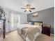 A spacious bedroom filled with natural light from the large window and featuring a ceiling fan and soft carpeting at 10781 Moore St, Westminster, CO 80021
