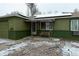 Green, single-story home with a covered front porch and a bench, solar panels, and some snow at 1134 Del Mar Pkwy, Aurora, CO 80010