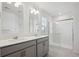 Bright bathroom featuring double sinks, quartz countertops, tiled floors, and glass-enclosed shower at 4115 Marble Dr, Mead, CO 80504