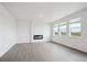 Bright living room featuring hard wood floors, a fireplace, and three windows bringing in natural light at 4115 Marble Dr, Mead, CO 80504
