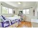 Bright bedroom featuring hardwood floors, two windows, and stylish decor, perfect for a  at 6484 Kendall St, Arvada, CO 80003