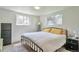 Well-lit bedroom with hardwood floors, featuring a metal frame bed and two windows for natural light at 6484 Kendall St, Arvada, CO 80003