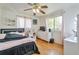 Stylish bedroom with wood floors, a black bed, a dresser with a TV, and pink curtains for a modern feel at 6484 Kendall St, Arvada, CO 80003