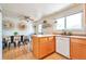 Open kitchen dining area with light wood cabinetry and white appliances at 6484 Kendall St, Arvada, CO 80003