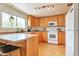 Cozy kitchen with light wood cabinets, modern appliances, and a breakfast bar at 6484 Kendall St, Arvada, CO 80003