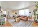 Bright and airy living room with hardwood floors, a hanging chair, and large windows at 6484 Kendall St, Arvada, CO 80003