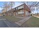 Multi-story brick condo building with balconies, gravel landscaping, and mature trees at 230 E Highline Cir # 101, Centennial, CO 80122