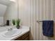 Half bathroom featuring decorative wallpaper, a mirror, vanity, and a towel bar with a blue towel at 3695 S Kittredge St # C, Aurora, CO 80013