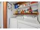 Functional laundry area with a washer and dryer, storage shelves, and laundry supplies at 3695 S Kittredge St # C, Aurora, CO 80013