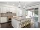 Open kitchen with granite counters, large island, and stainless appliances leading to an outdoor patio at 89 Oneida St, Denver, CO 80230