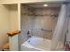 Bathtub with tiled shower and safety bar at 11600 E Adriatic Pl, Aurora, CO 80014