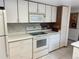 Functional kitchen featuring white cabinets and appliances, offering a clean and efficient cooking space at 11600 E Adriatic Pl, Aurora, CO 80014