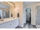 Bathroom featuring double sinks, walk-in closet, and glass enclosed shower at 16200 Hedgeway Dr, Parker, CO 80134