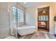 Bathroom including a glass shower and freestanding tub with views of the bedroom at 16200 Hedgeway Dr, Parker, CO 80134