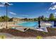 Community pool with lounge chairs, tables, umbrellas and clear blue skies on a sunny day at 16200 Hedgeway Dr, Parker, CO 80134