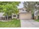 Charming two-story home with a well-manicured lawn, lush trees, and a welcoming two-car garage at 16200 Hedgeway Dr, Parker, CO 80134