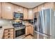 Charming kitchen features stainless steel appliances, wood cabinets, granite countertops, and hardwood floors at 16200 Hedgeway Dr, Parker, CO 80134