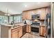 Well-lit kitchen features stainless steel appliances, granite countertops, wood cabinets and hardwood floors at 16200 Hedgeway Dr, Parker, CO 80134