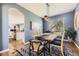 Stylish dining room featuring a wood table, upholstered chairs, a modern light fixture, and blue accent walls at 1153 Berganot Trl, Castle Pines, CO 80108