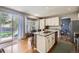 Bright kitchen with white cabinetry, granite countertops, a center island, and a sliding glass door to the patio at 1153 Berganot Trl, Castle Pines, CO 80108