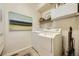Functional laundry room with modern washer and dryer, ample storage space, and neutral decor, for convenient chore management at 1153 Berganot Trl, Castle Pines, CO 80108