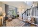 Elegant living room with high ceilings, hardwood floors, stylish decor, and an adjacent staircase at 1153 Berganot Trl, Castle Pines, CO 80108