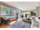 Open-concept living room with lots of natural light, hardwood floors, and a cozy seating area next to a modern kitchen at 1153 Berganot Trl, Castle Pines, CO 80108