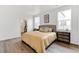 Bedroom featuring wood-look floors, modern decor, and windows providing ample natural light at 4692 Hatcher Dr, Brighton, CO 80601