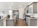 Bright kitchen with gray cabinets, stainless appliances, granite counters and wood-look floors at 4692 Hatcher Dr, Brighton, CO 80601